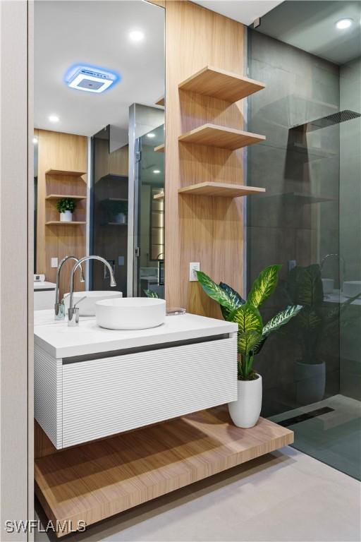 bathroom with vanity and a tile shower