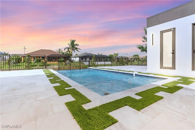 pool at dusk with a patio area