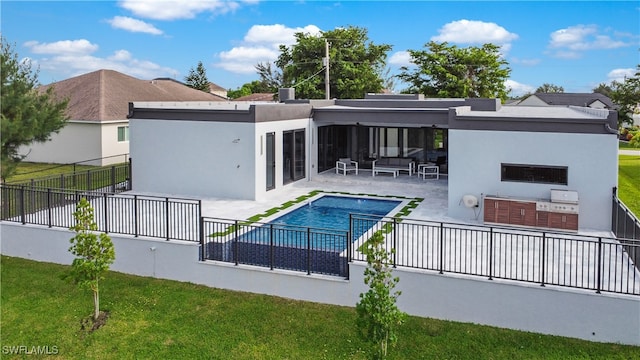 back of property featuring a patio area, a yard, exterior kitchen, a fenced in pool, and outdoor lounge area