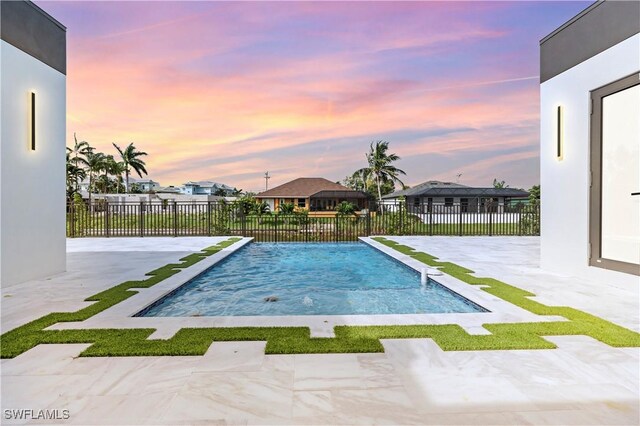 pool at dusk with a patio