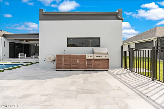 view of patio featuring a swimming pool, exterior kitchen, grilling area, and ceiling fan