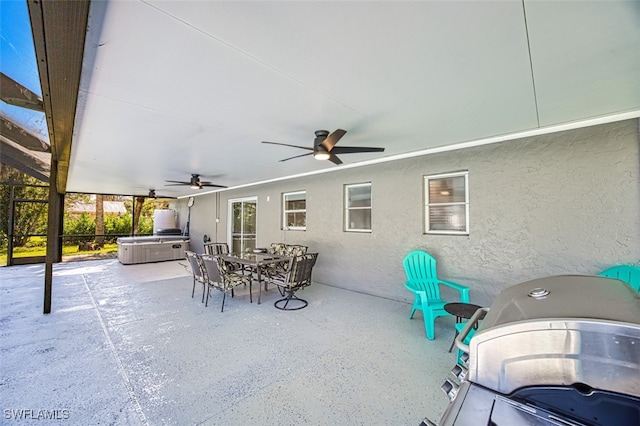 view of patio / terrace with ceiling fan, area for grilling, glass enclosure, and a hot tub