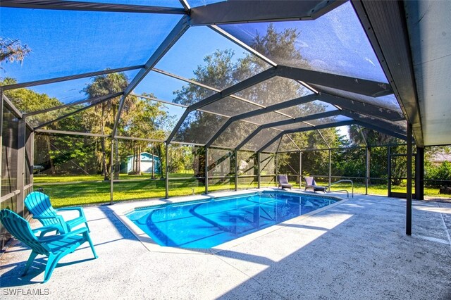 view of swimming pool featuring a patio, a storage shed, a yard, and a lanai