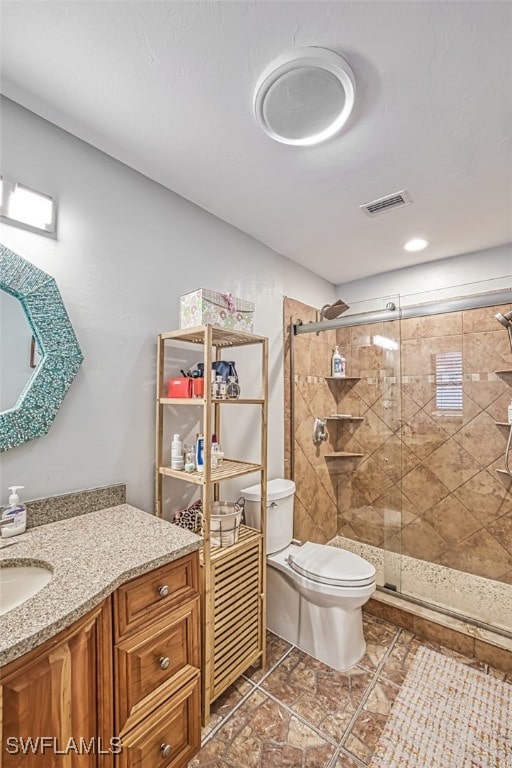 bathroom featuring walk in shower, vanity, and toilet