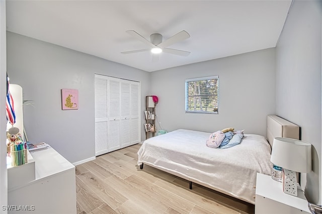 bedroom with ceiling fan, light hardwood / wood-style flooring, and a closet