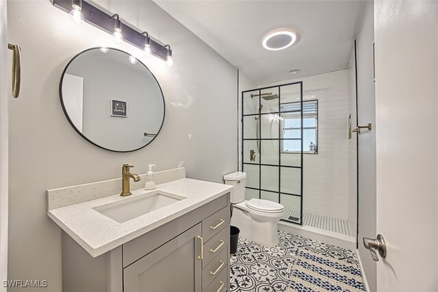 bathroom featuring vanity, toilet, and tiled shower