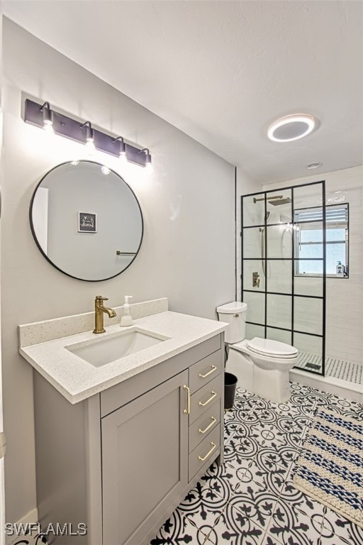 bathroom featuring a tile shower, vanity, toilet, and tile patterned floors