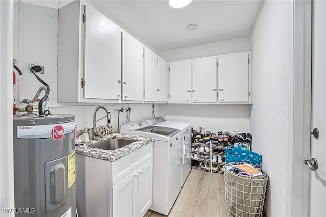 washroom with cabinets, light wood-type flooring, sink, water heater, and washer and clothes dryer