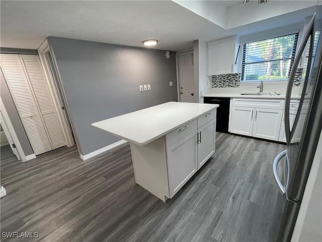 kitchen featuring a center island, light countertops, freestanding refrigerator, white cabinets, and dishwasher