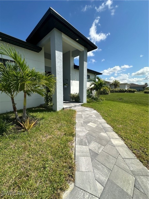 view of exterior entry featuring a yard