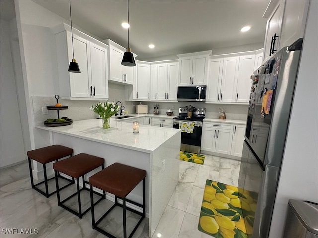 kitchen with white cabinets, kitchen peninsula, pendant lighting, stainless steel appliances, and sink