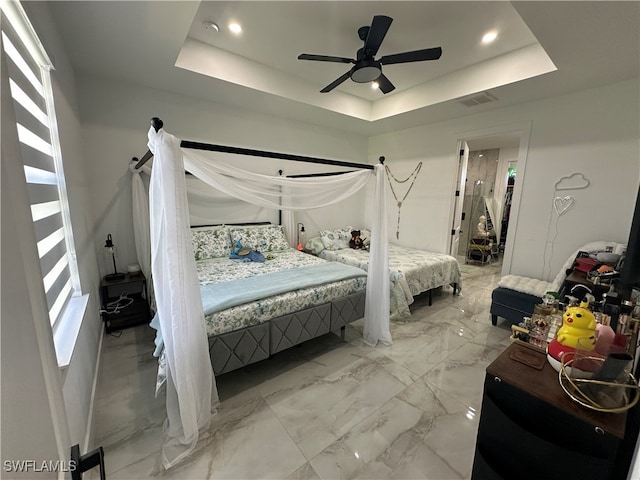 bedroom featuring a raised ceiling and ceiling fan