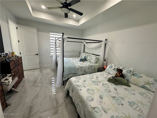 bedroom featuring a tray ceiling and ceiling fan