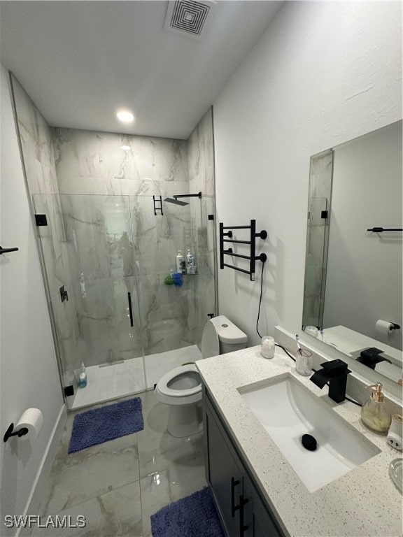 bathroom featuring vanity, toilet, and a shower with shower door