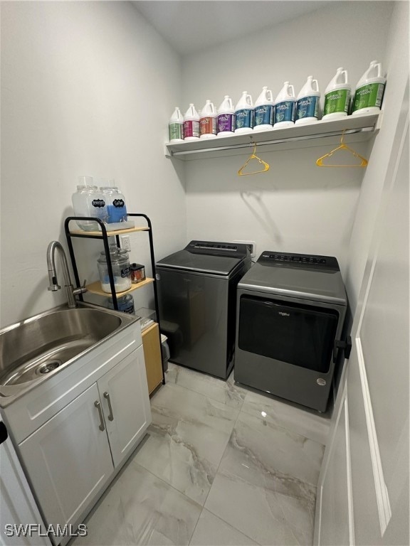 clothes washing area with cabinets, sink, and washing machine and dryer