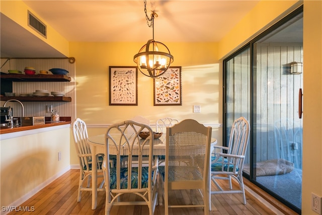 dining space with a chandelier and hardwood / wood-style flooring