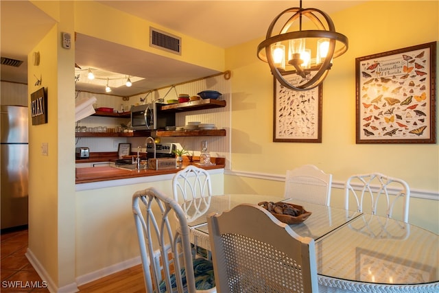 dining area with wood-type flooring and a notable chandelier