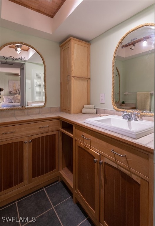 bathroom featuring a raised ceiling, vanity, and tile patterned floors