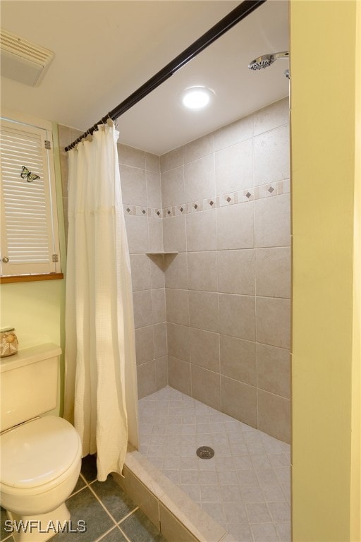 bathroom with walk in shower, tile patterned flooring, and toilet