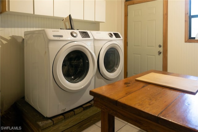 laundry room with cabinets, tile patterned flooring, and washing machine and clothes dryer