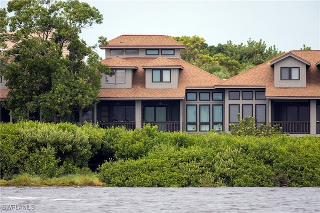 back of property featuring a water view