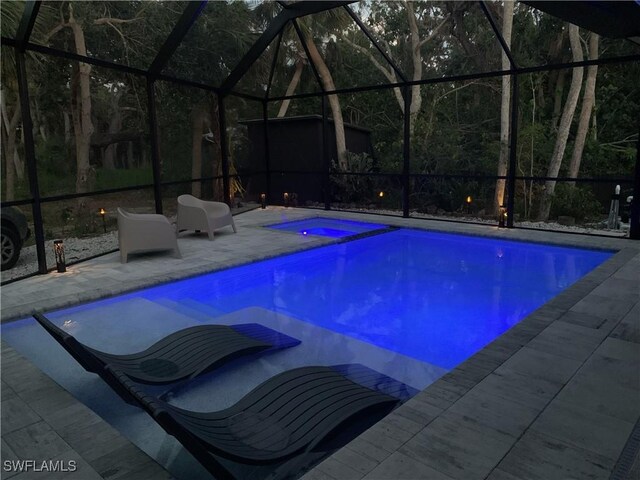 view of swimming pool with a patio and a lanai