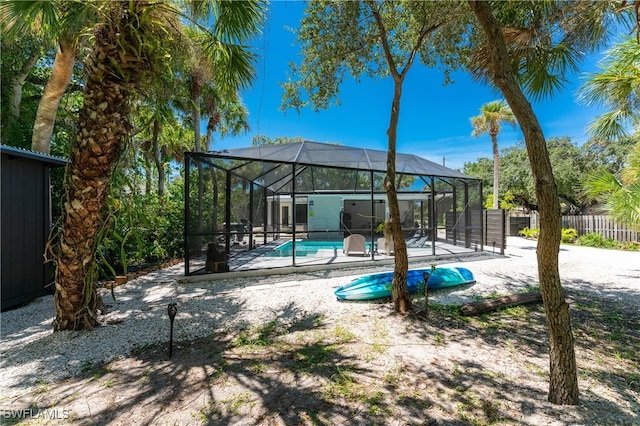 view of pool with glass enclosure and a patio