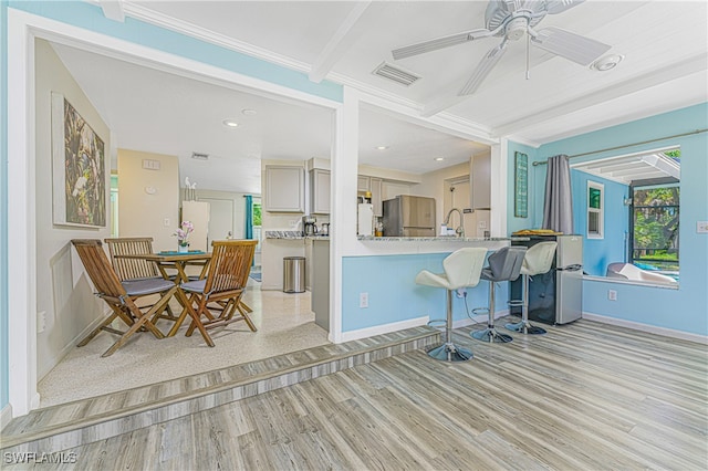 kitchen with stainless steel fridge, light hardwood / wood-style floors, beam ceiling, and ceiling fan