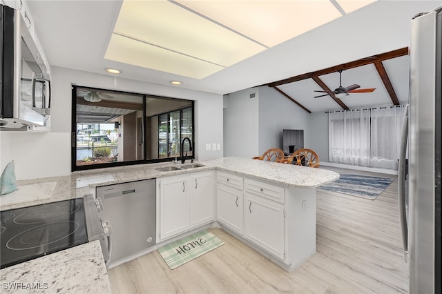 kitchen featuring lofted ceiling with beams, white cabinetry, kitchen peninsula, appliances with stainless steel finishes, and ceiling fan