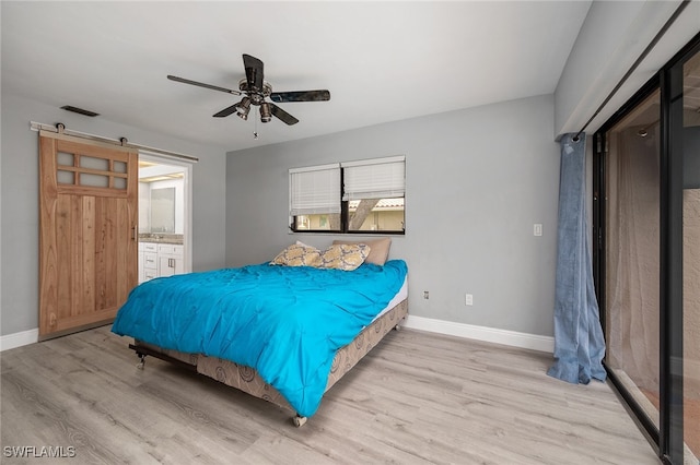 bedroom with light wood-type flooring, connected bathroom, and ceiling fan