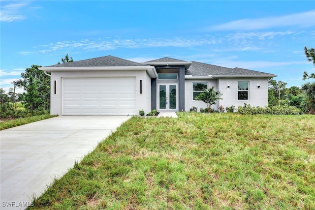 view of front of house featuring french doors, a front yard, and a garage