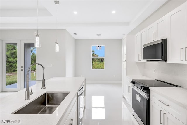 kitchen featuring white cabinets, hanging light fixtures, sink, appliances with stainless steel finishes, and light stone countertops