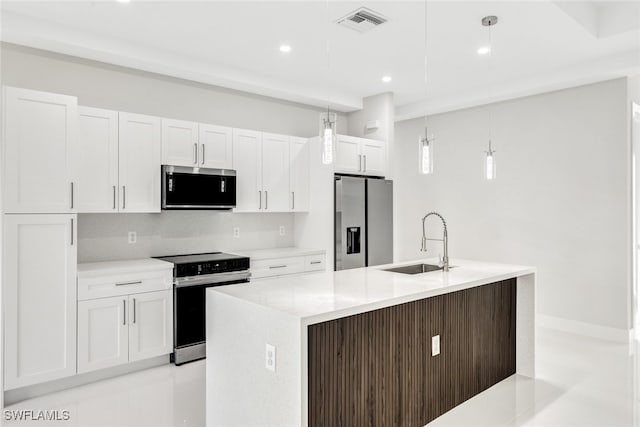 kitchen with a kitchen island with sink, sink, decorative light fixtures, and appliances with stainless steel finishes