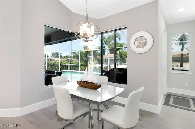 dining area with an inviting chandelier and light hardwood / wood-style flooring