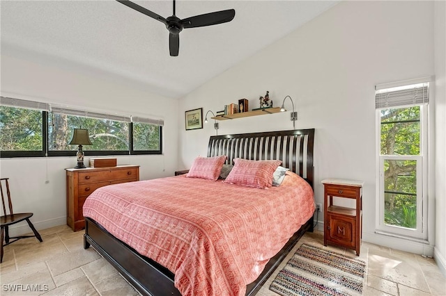 bedroom featuring ceiling fan, lofted ceiling, and multiple windows