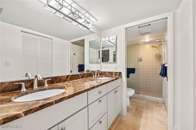 bathroom featuring toilet, vanity, and a tile shower