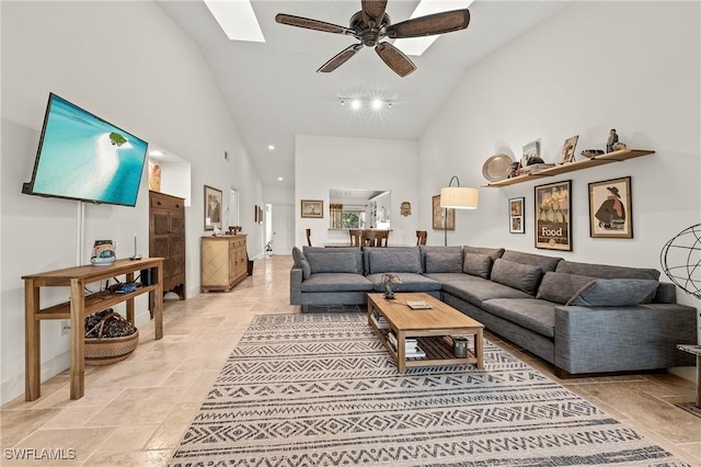 15330 Cedarwood Ln Unit 5-203, Naples, FL 34110 - living area featuring high vaulted ceiling, a ceiling fan, stone tile flooring, and a skylight