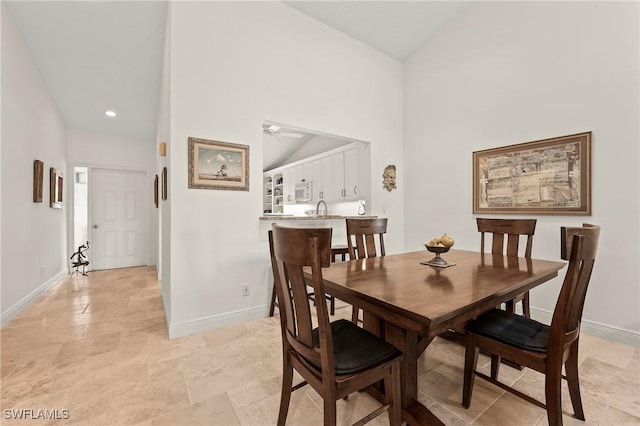 15330 Cedarwood Ln Unit 5-203, Naples, FL 34110 - dining area featuring baseboards, a ceiling fan, light stone finish flooring, and high vaulted ceiling