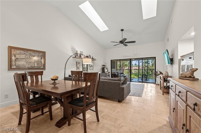 dining area with ceiling fan, high vaulted ceiling, and a skylight