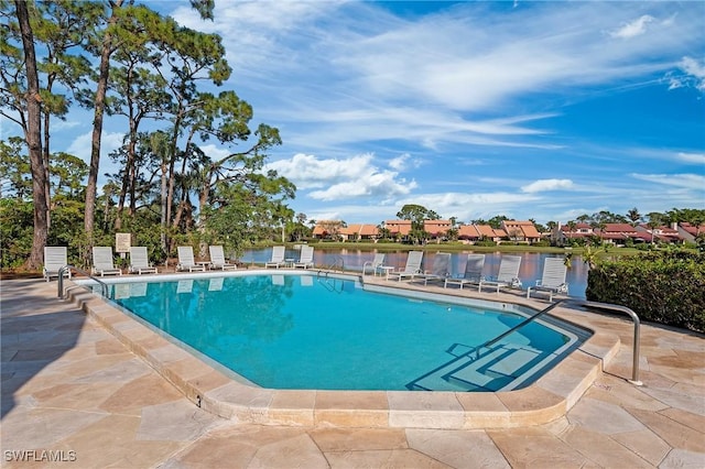 view of swimming pool featuring a water view and a patio area