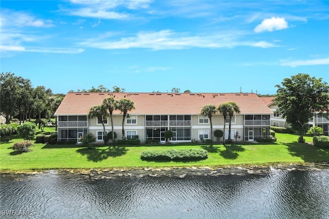 rear view of property with a water view and a yard