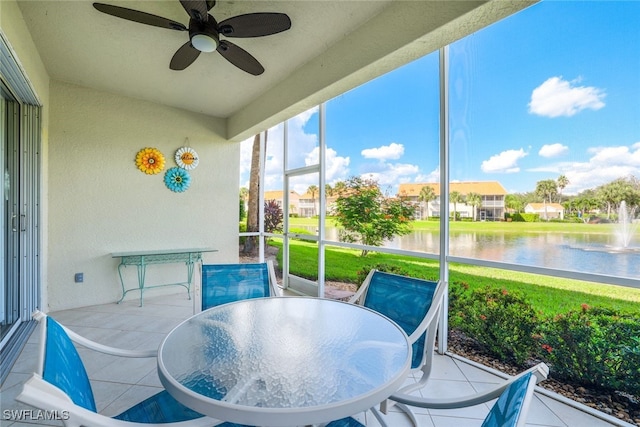 sunroom / solarium featuring ceiling fan and a water view