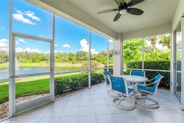 sunroom / solarium with ceiling fan and a water view