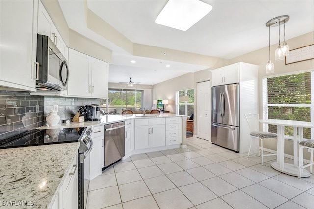 kitchen with stainless steel appliances, white cabinetry, and ceiling fan