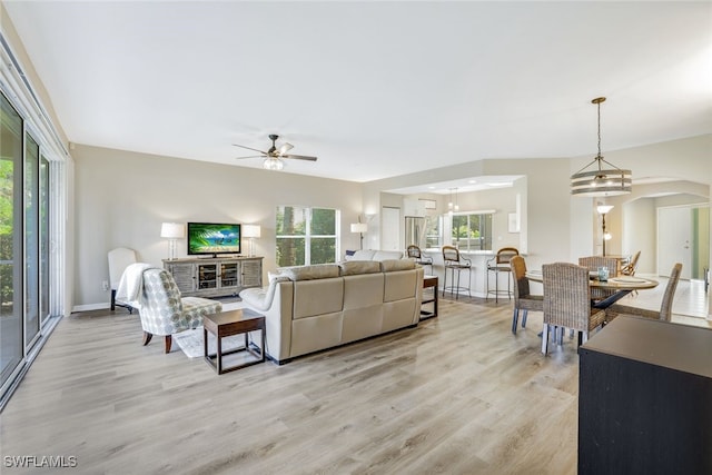 living room featuring light wood-type flooring, a healthy amount of sunlight, and ceiling fan