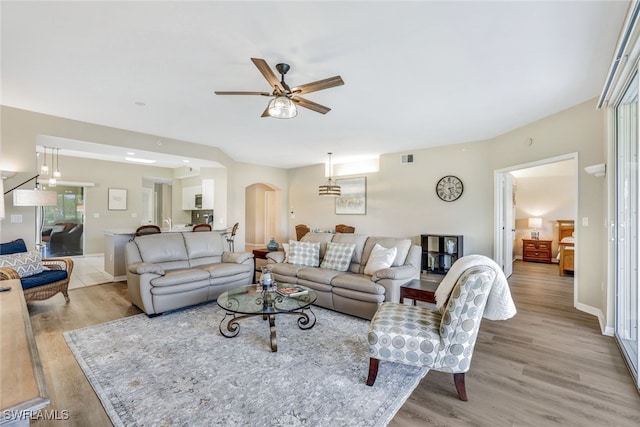 living room with light wood-type flooring and ceiling fan