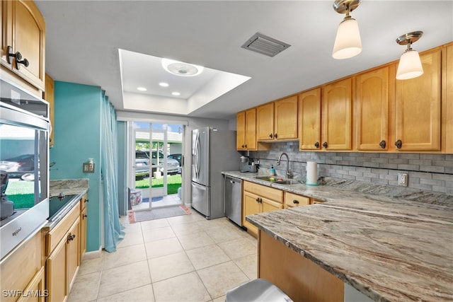 kitchen featuring appliances with stainless steel finishes, tasteful backsplash, light stone countertops, decorative light fixtures, and sink