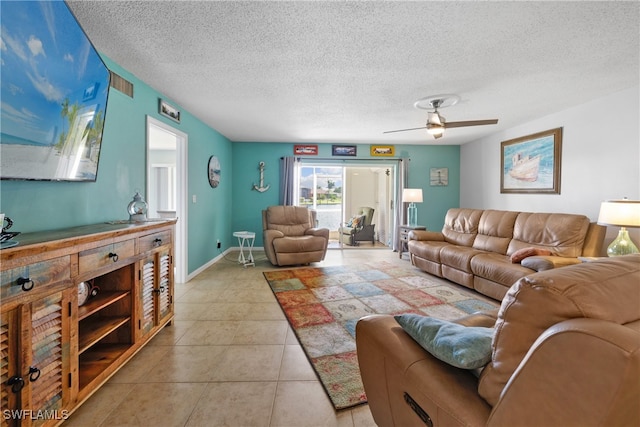 living room featuring ceiling fan, light tile patterned floors, and a textured ceiling