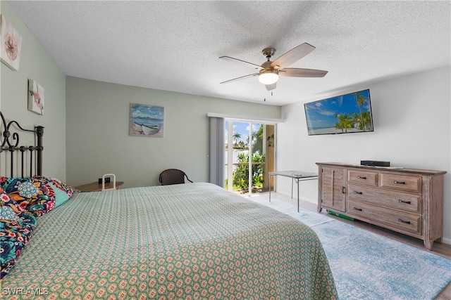 bedroom with light hardwood / wood-style flooring, ceiling fan, access to exterior, and a textured ceiling