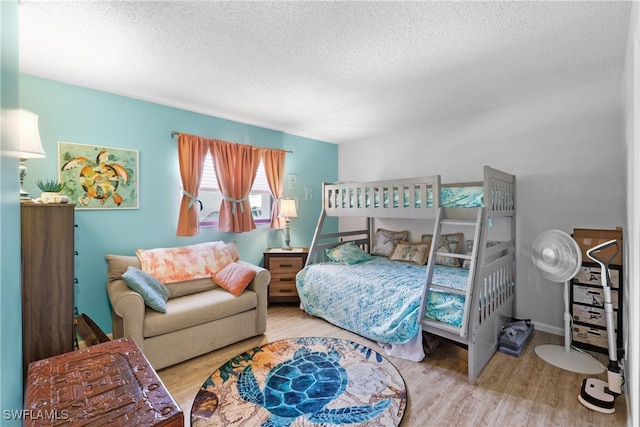 bedroom with a textured ceiling and light hardwood / wood-style floors